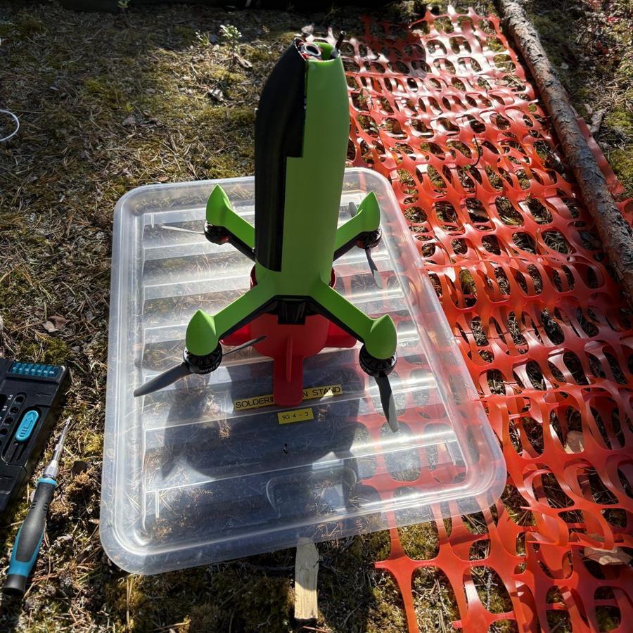 An earlier green airframe standing upright on its launch box in the field
